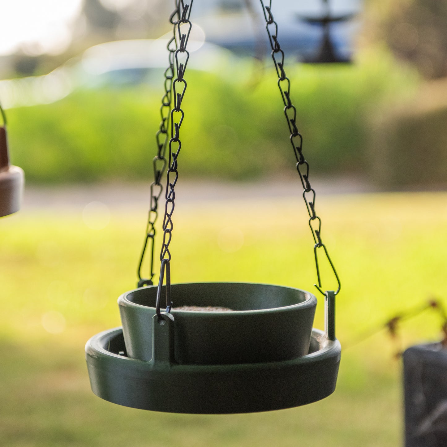 Close-up of forest green Bird Feeder Lite filled with bird seed