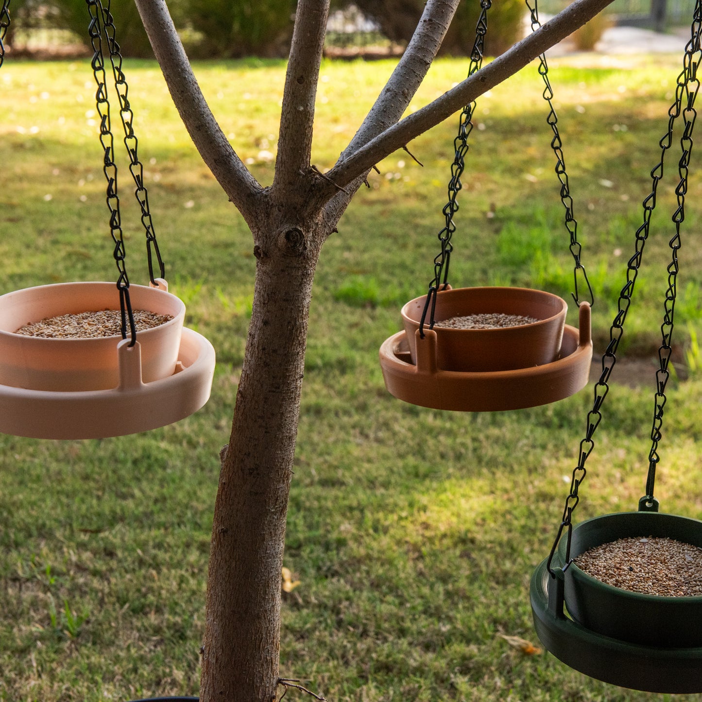 Group of three Bird Feeder Lites hanging together in a garden