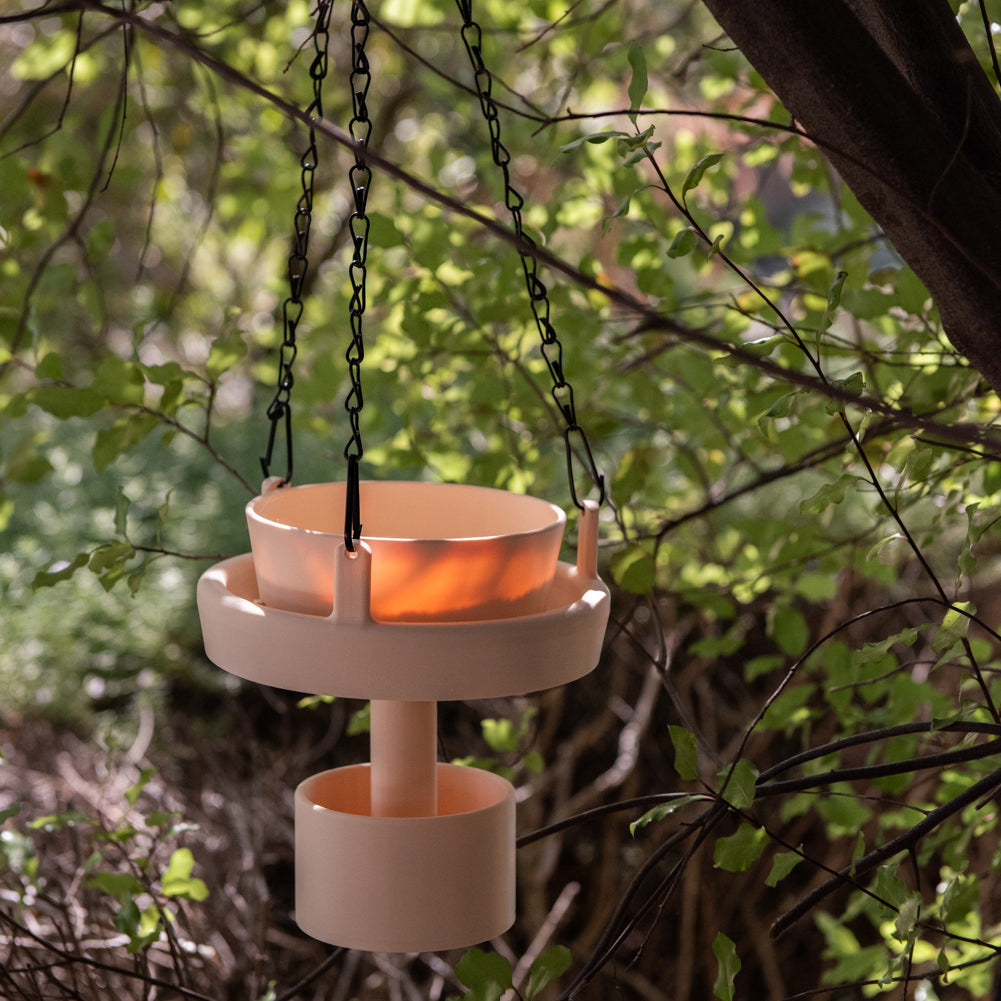 Cream Bird Feeder Original with removable bowl, hanging in a shady tree with dappled sunlight