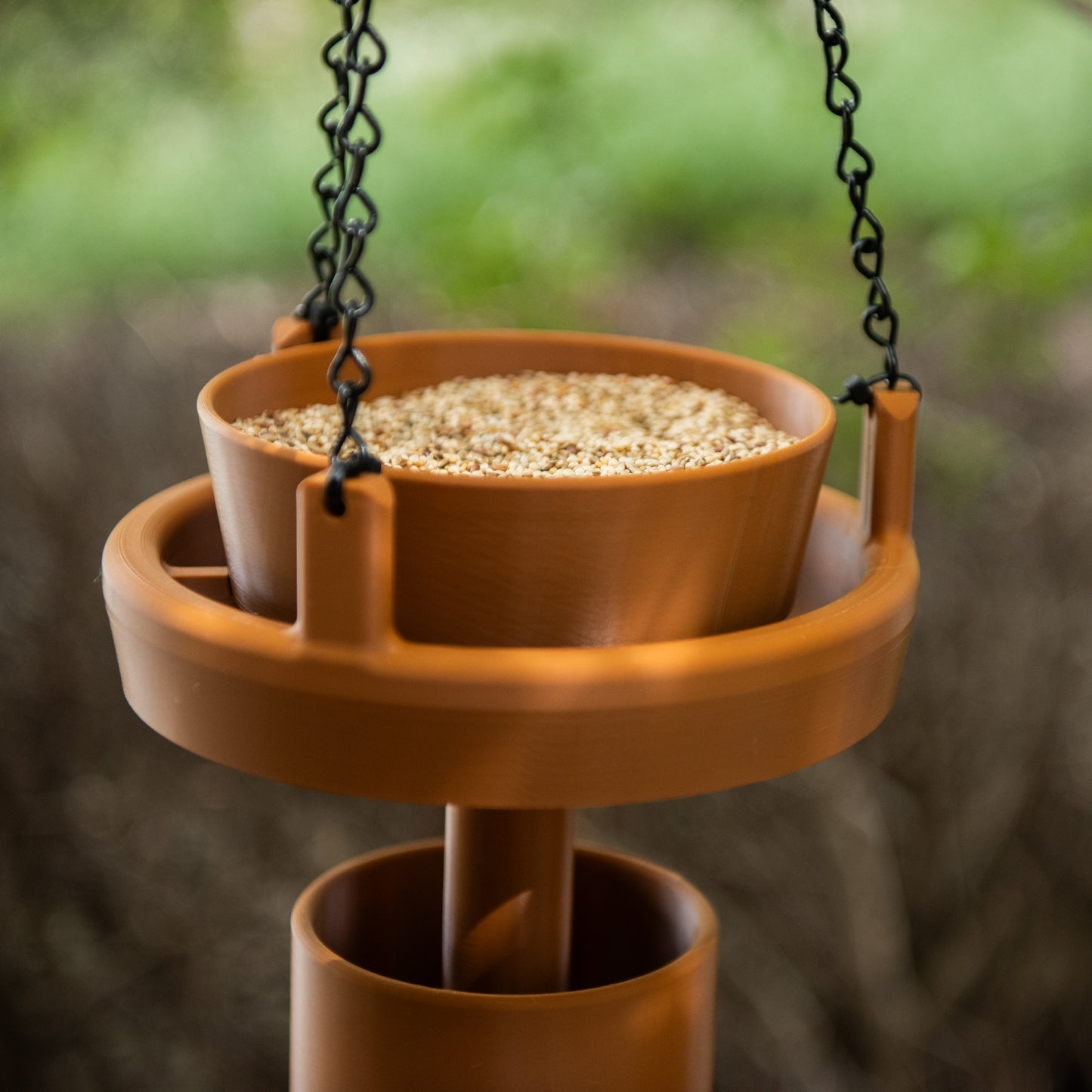 Terracotta Bird Feeder Original filled with bird seed in garden setting