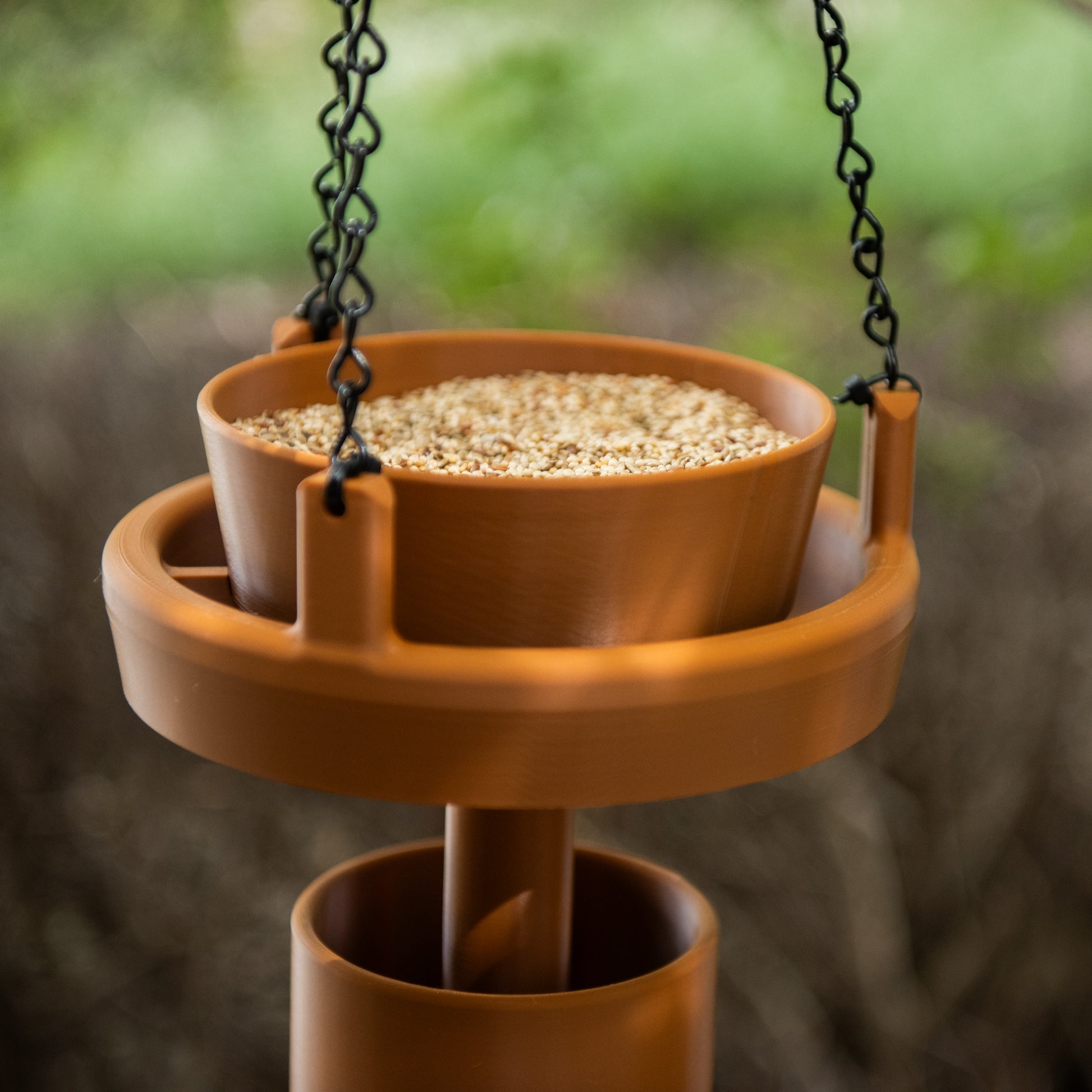 Terracotta Bird Feeder Original filled with bird seed in garden setting